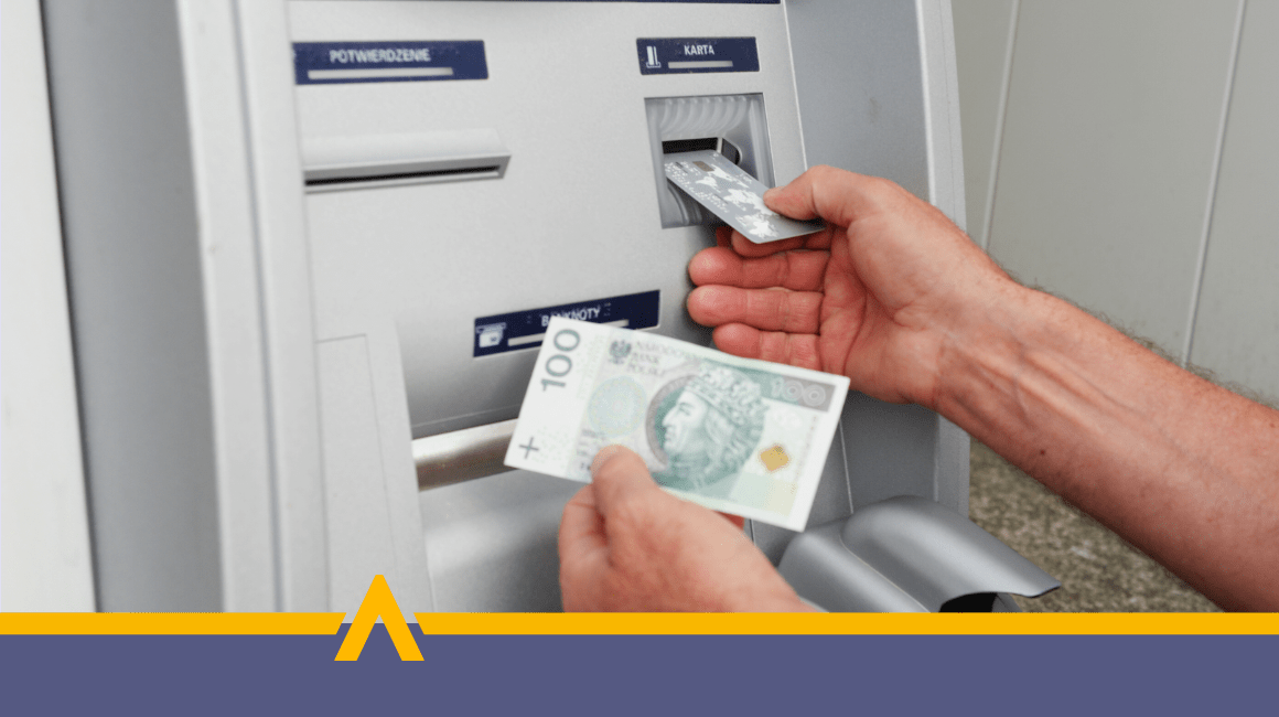 Osoba wypłacająca gotówkę z bankomatu – karta płatnicza i banknot 100 zł