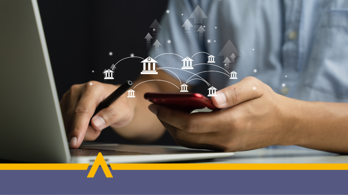 Osoba wykonująca przelew bankowy za pomocą smartfona i laptopa