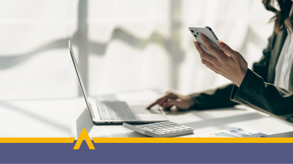 Kobieta korzystająca z laptopa i smartfona w jasnym biurze